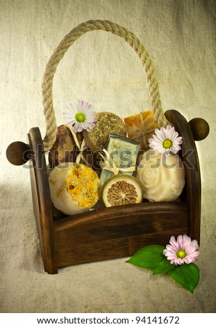 Composition of the basket full of handmade soap with some flower decoration.