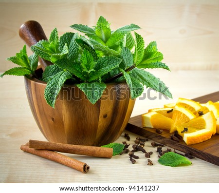 Mortar and pestle, with mint, spices and orange.