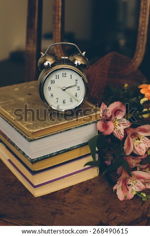 Clock with books and flowers in vintage color