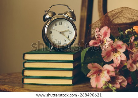 Clock with books and flowers in vintage color