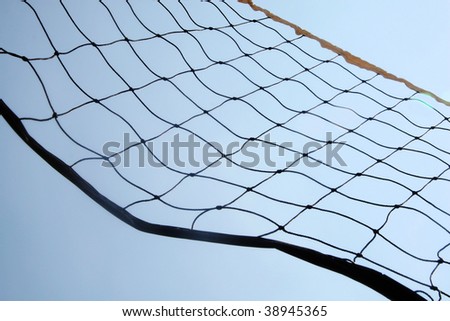 A close up beach volley ball net in front of sky.
