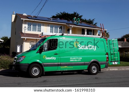 HALF MOON BAY, CA - CIRCA NOVEMBER 2013 - SolarCity technicians install solar panels on the roof of a single-family residence. SolarCity (SCTY) is a publicly traded company based in San Mateo, CA.