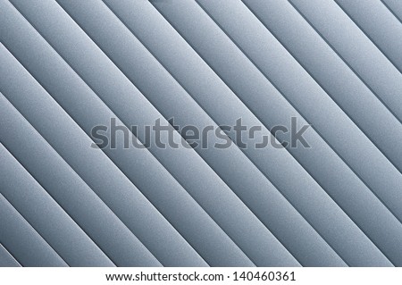 Detail of silver grey roller door/blind with parallel striped lines.