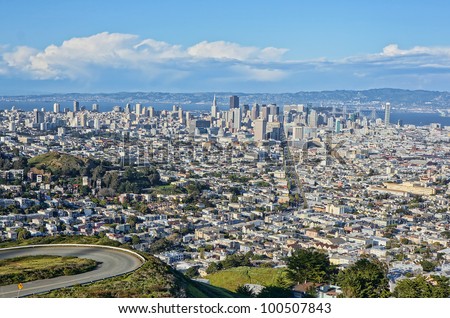 View of the city of San Francisco from Twin Peaks on a sunny day with clouds.