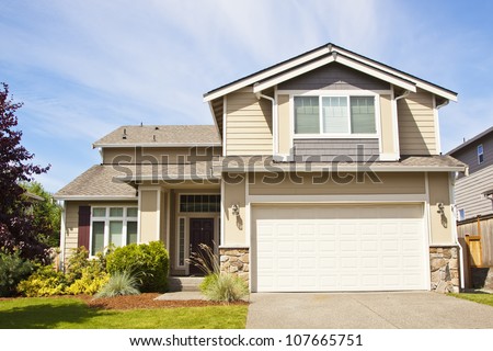 Suburban home with front porch,garage and blue sky