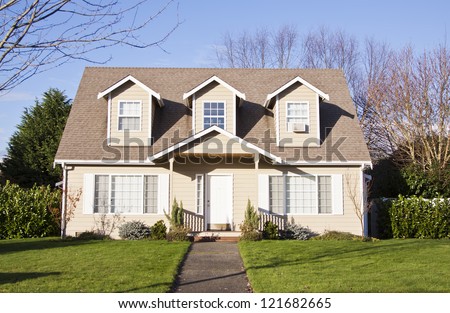 Luxury Family House With Landscaping On The Front And Blue Sky On Background