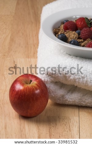 Bowl of cereal on a towel with apple