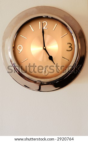 Clock hanging on the wall. It is indicating five o'clock - time to go home from work