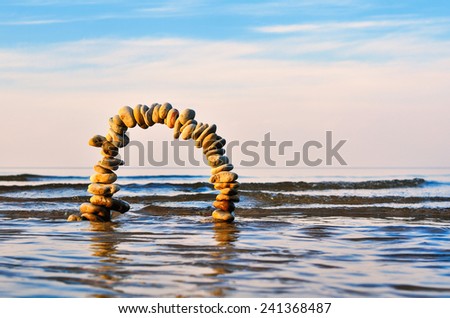 Arch of pebbles on the surface of the sea