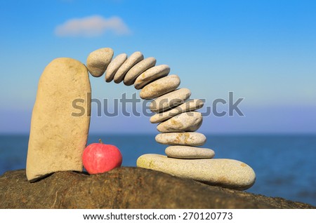 Arch of pebbles and apple between of the stones on the coast