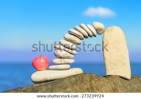 Arch of pebbles and apple between of the stones on the coast
