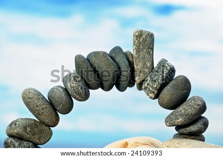 Arch from a dark sea pebble in the summer morning on a beach