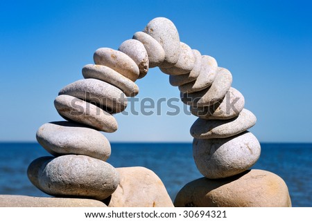 Balance arc of the white pebbles on the sea coast