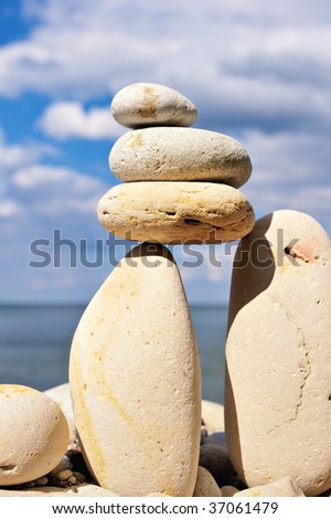 Three pebble in balance between the two boulders