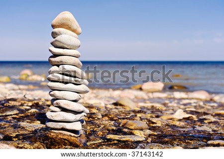 Several flat pebbles fold up together as a stack on the coast