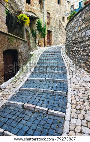 Sidewalk between old homes paved with the cobblestones
