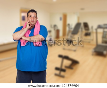 Pensive fat man playing sport in the gym
