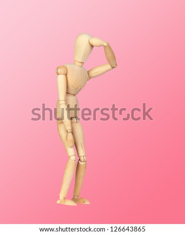 Jointed wooden mannequin representing discouragement isolated on a pink background