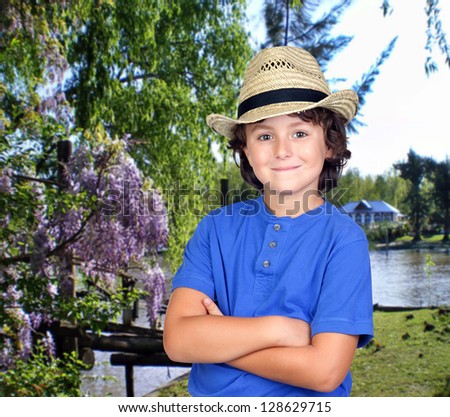 Funny child with straw hat in the park with a lake