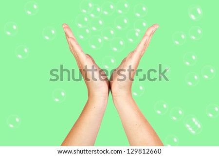 Open Hands catching bubbles on green background