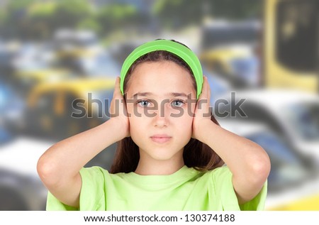 Frightened girl with ears plugged with many cars of background