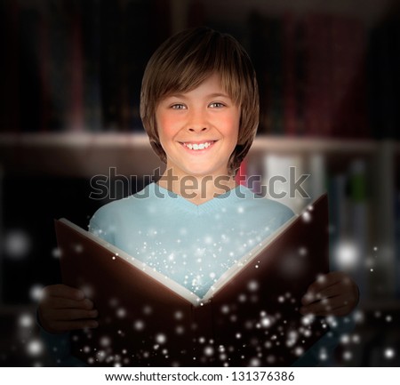 Preteen boy with a lighted book reading in the library
