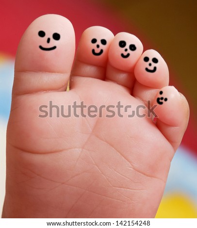 Nice foot of a baby with smiley faces painted toes Nice foot of a baby with smiley faces painted toes
