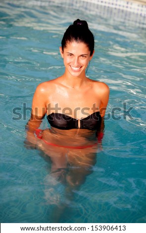 Attractive girl with a black bikini in the pool