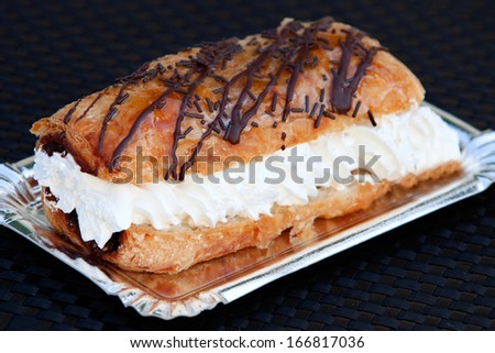 Delicious cake with pastry cream and chocolate on silver tray