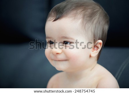 Portrait of a cute baby with black eyes smiling