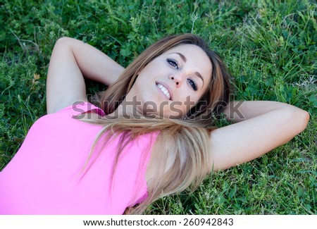 Cool pretty woman with pink t-shirt lying on the grass