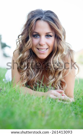 Cool pretty lying girl on the grass with a beautiful smile