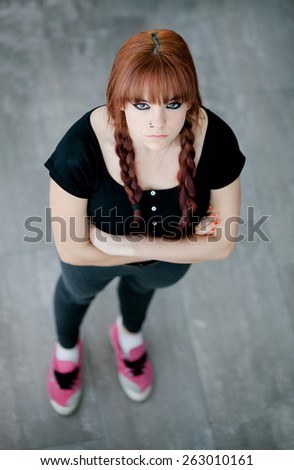 Rebellious teenager girl with red hair very angry view from above