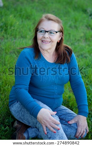 Elderly woman in her 68 years smiling outdoors