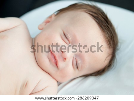 Tender baby smiling while nap in the crib