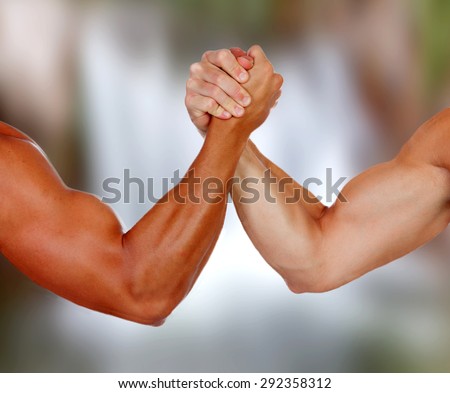 Strong arms with muscles taking a pulse with a blurred background