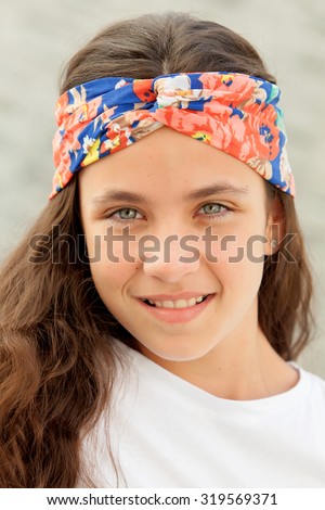 Pretty teenager girl with a flowered headband smiling