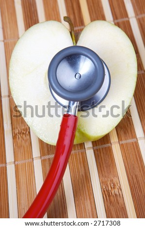 stethoscope and apple with a heart shape (a healthful food and heals)