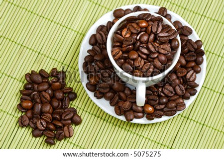 Coffee beans in a cup    - focus in the first plane -