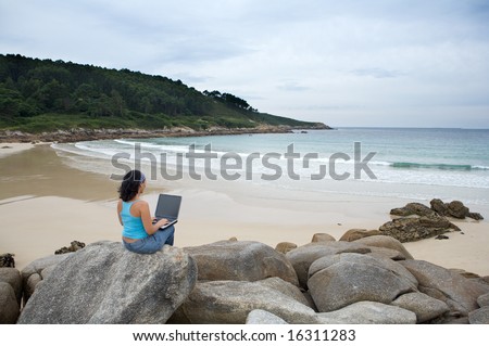 Businesswoman with laptop computer on the beach