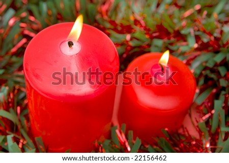 Red candles of Christmas lit with red and green ribbon