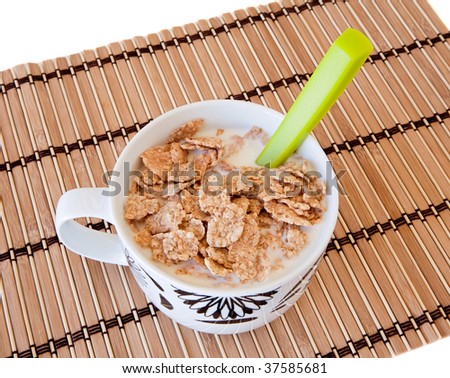 Breakfast bowl of cereal and milk on bamboo tablecloth