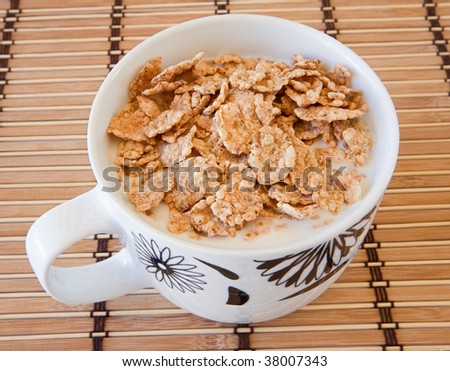 Breakfast bowl of cereal and milk on bamboo tablecloth