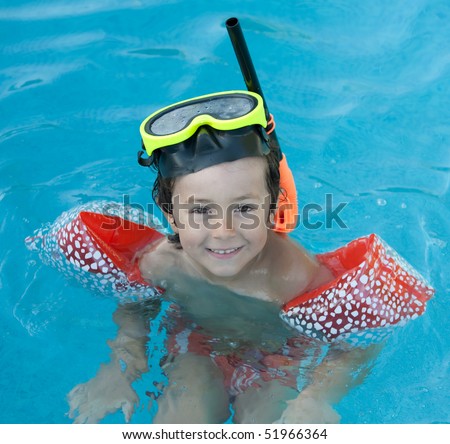 Little child with diving goggles and snorkel swimming in the water