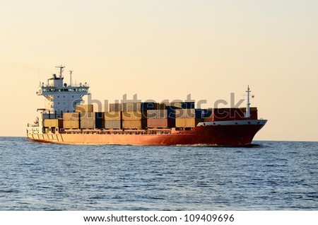 cargo container ship sailing at the sunset