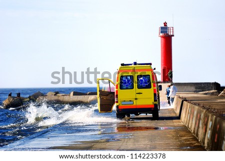 ambulance car rescuing people at the sea shore during storm