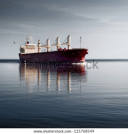 cargo ship sailing in still water near port of Riga