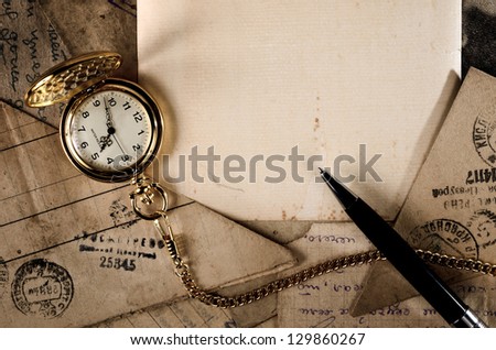 vintage pocket clock and pen on old letters texture