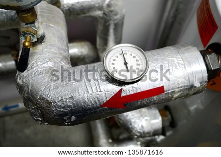 industrial thermometer on a water pipeline in a boiler room
