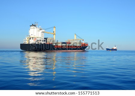 cargo container ship and small cargo ship sailing in still water